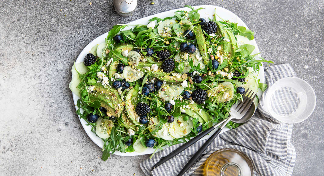 Insalata di rucola e avocado con feta e frutti di bosco